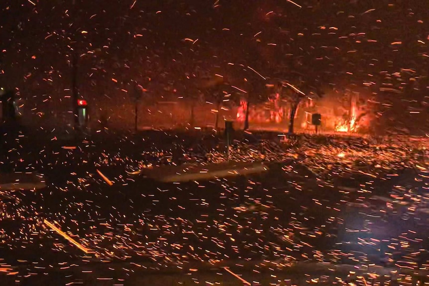 Bright yellow and orange sparks fly around a darkened streetscape.