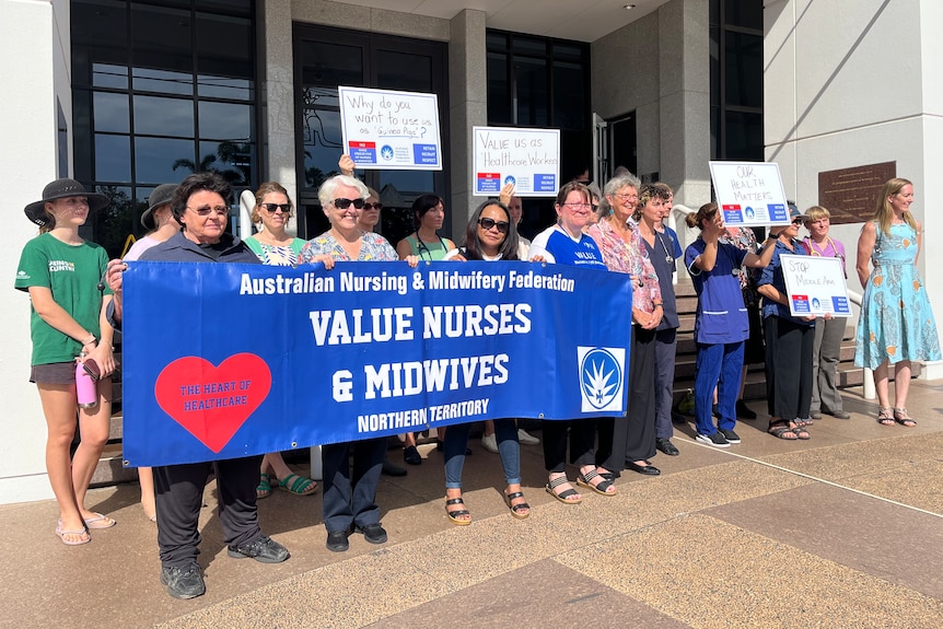 A photo showing a group of Northern Territory nurses holding a sign saying Australian nursing and midwifery frederation