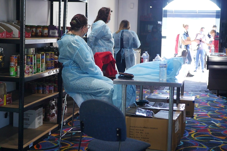 Staff wearing PPE at a vaccine hub.