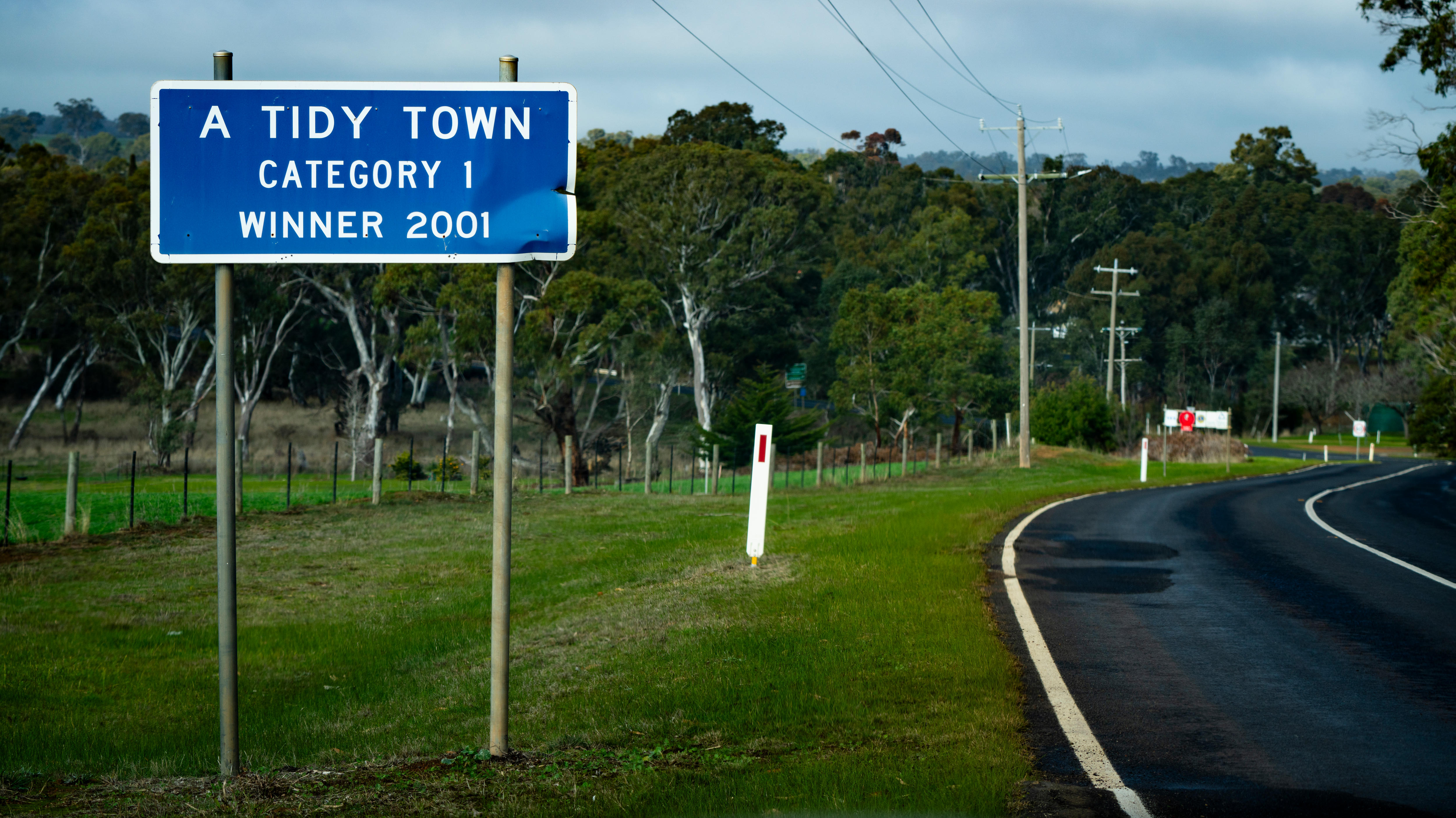 A sign by the road saying 'A Tidy Town Catergory 1 winner 2001'.