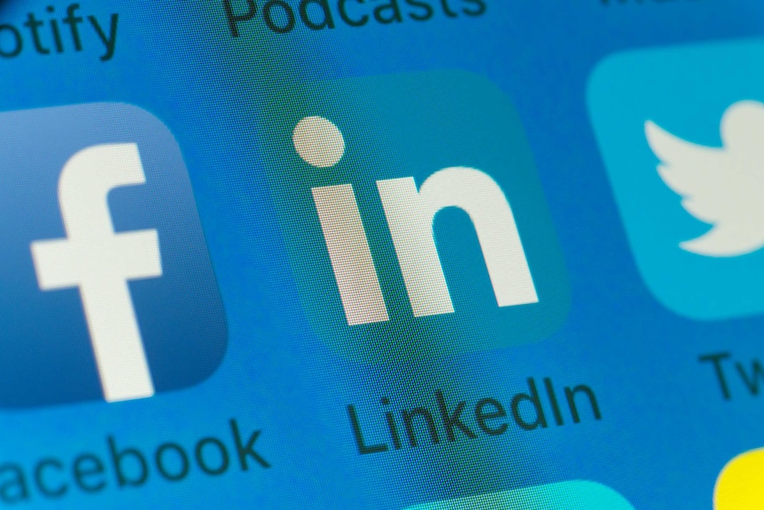 A close-up of apps on a smartphone screen, with the LinkedIn logo in the middle.