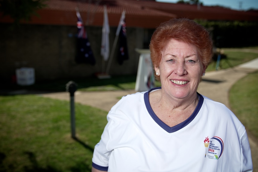 A woman with short red hair smiles.