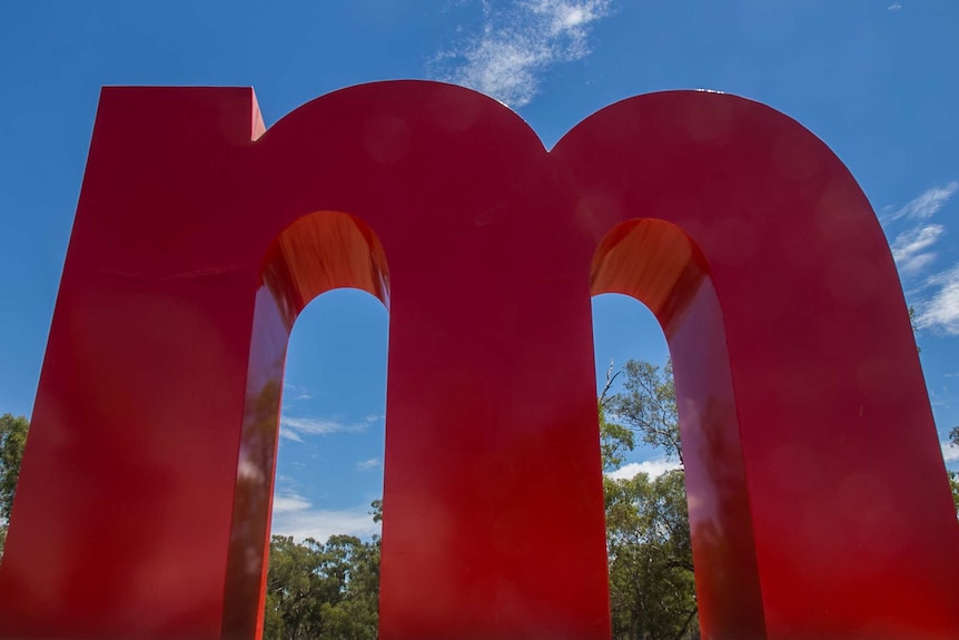 A huge red letter m in a paddock