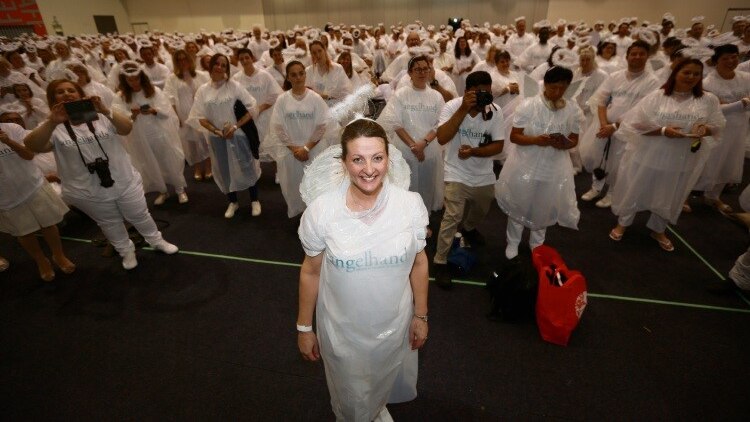 Dr O'Neill dressed as an angel, and surrounded by angels, at the 2018 attempt to break the world record.