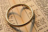 A wedding ring sits on a bible.