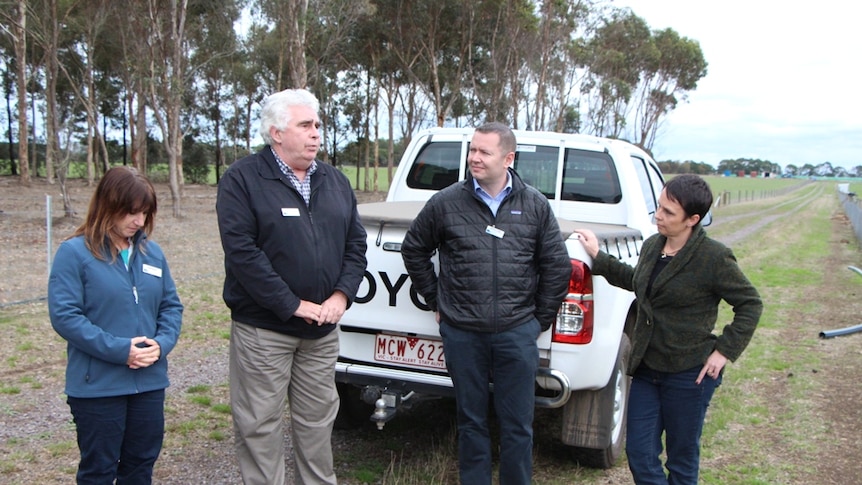 Three researchers standing behind a ute talking with Victoria's agriculture minister