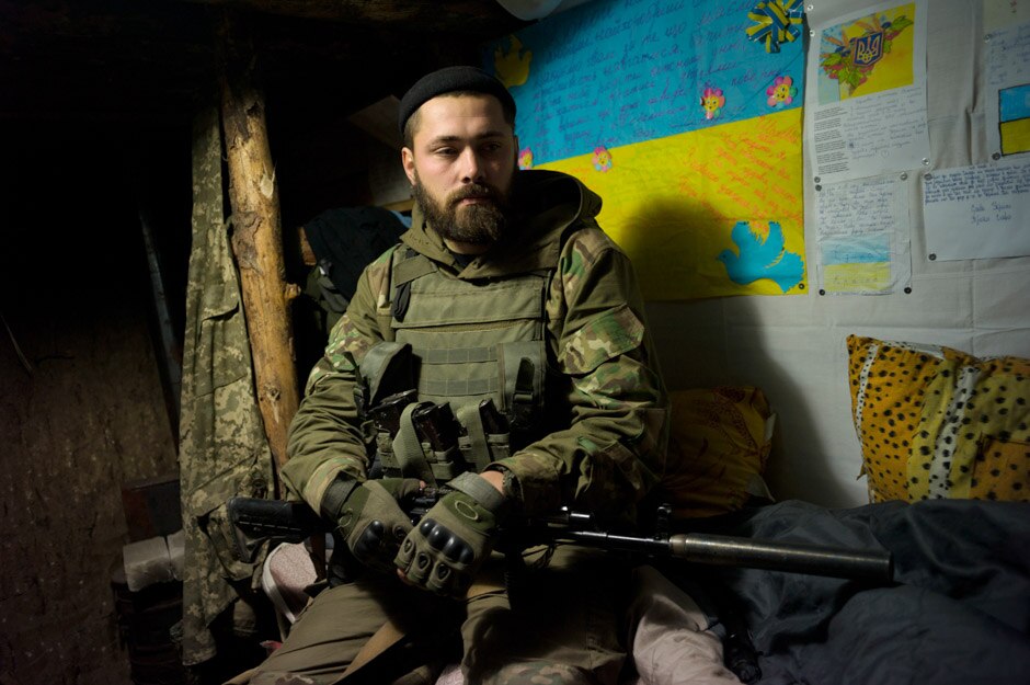 Maxim (29) in the underground earth and wood bunker that has been his home for the last 3 months, on the Mariupol front.
