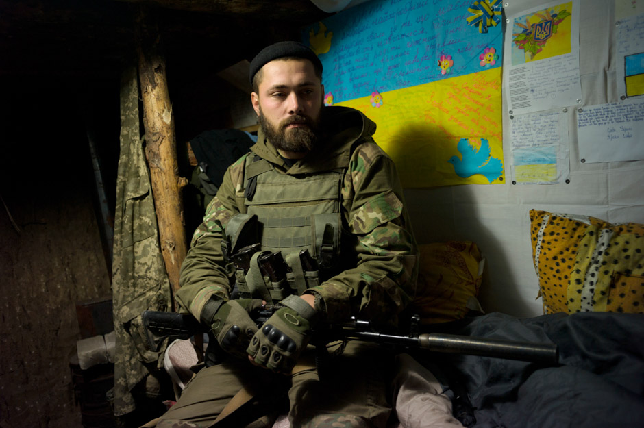 Maxim (29) in the underground earth and wood bunker that has been his home for the last 3 months, on the Mariupol front.