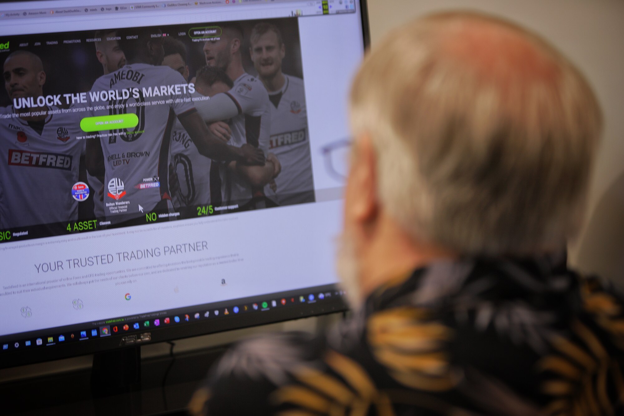 Older man looking at a website on a computer screen.