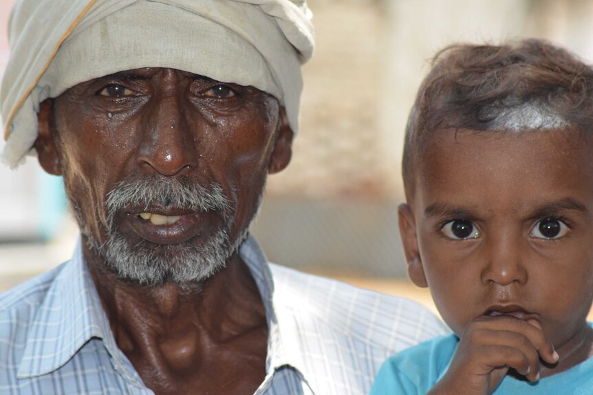 A closeup of a Muslim man and his son in India.