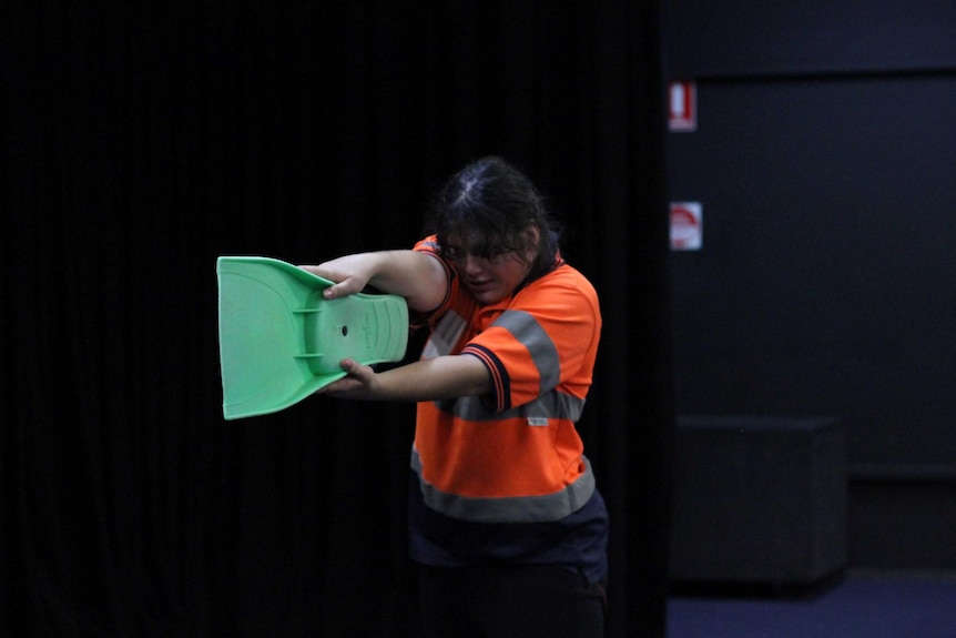 A woman with her back turned to the camera with a sash tied around her head.