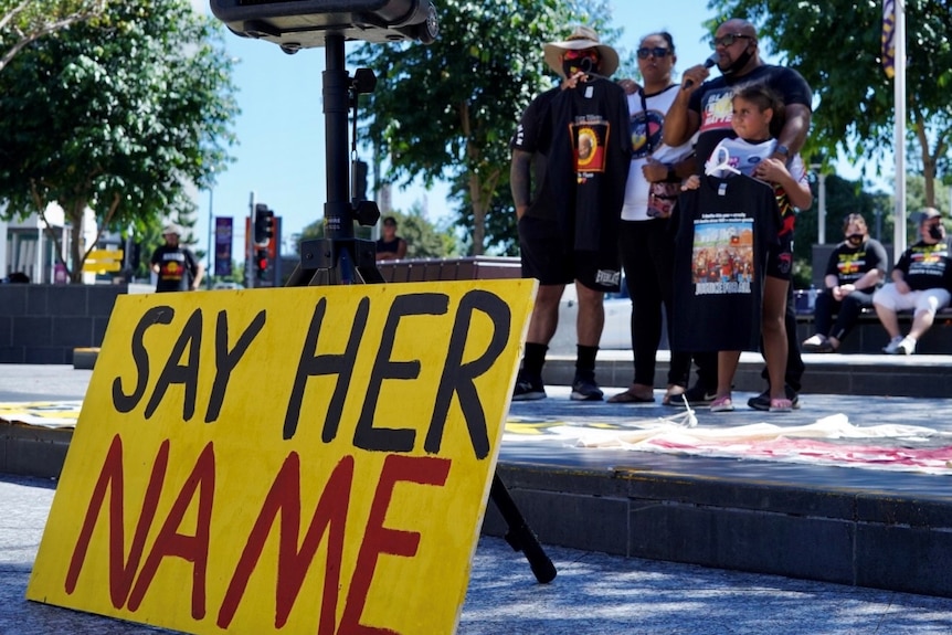 A sign at a Brisbane rally reads 'say her name'