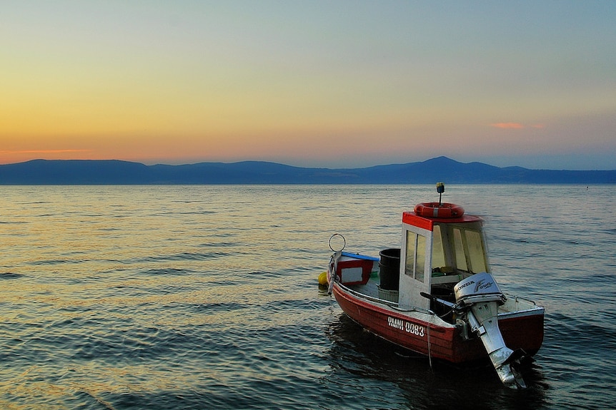 A boat on the water with a vast horizon before it