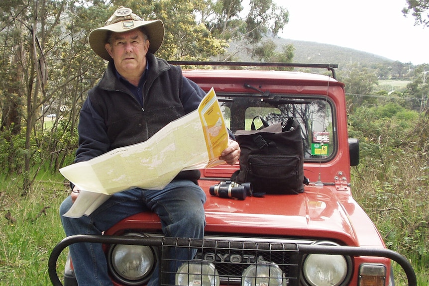 Col Bailey sits on the bonnet of his car.