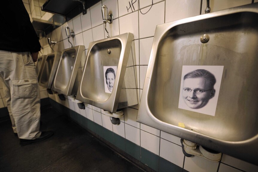 A man urinates on photos of bankers in the toilets of the Sodoma bar in central Reykjavik.