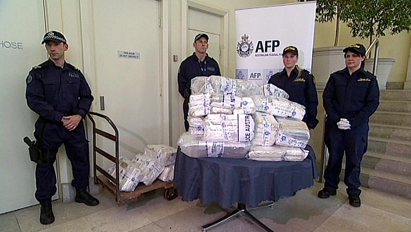 AFP and Customs officials in Melbourne stand next to more than 270 kilograms of cocaine
