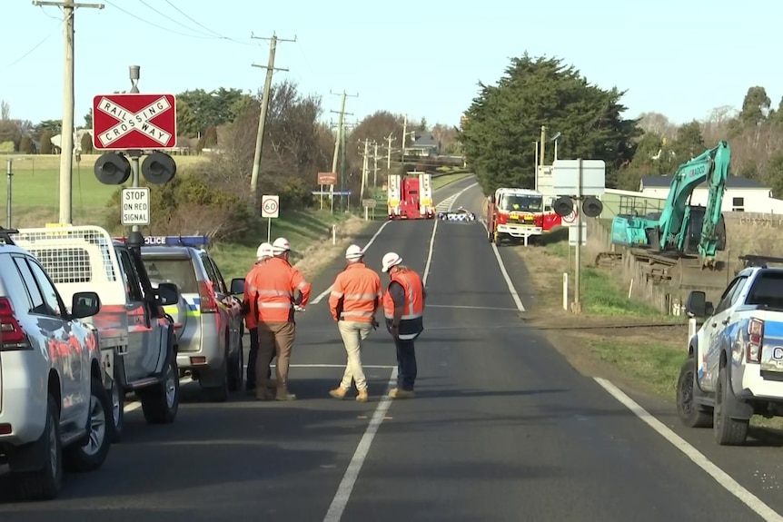 Construction workers near a railway crossing.