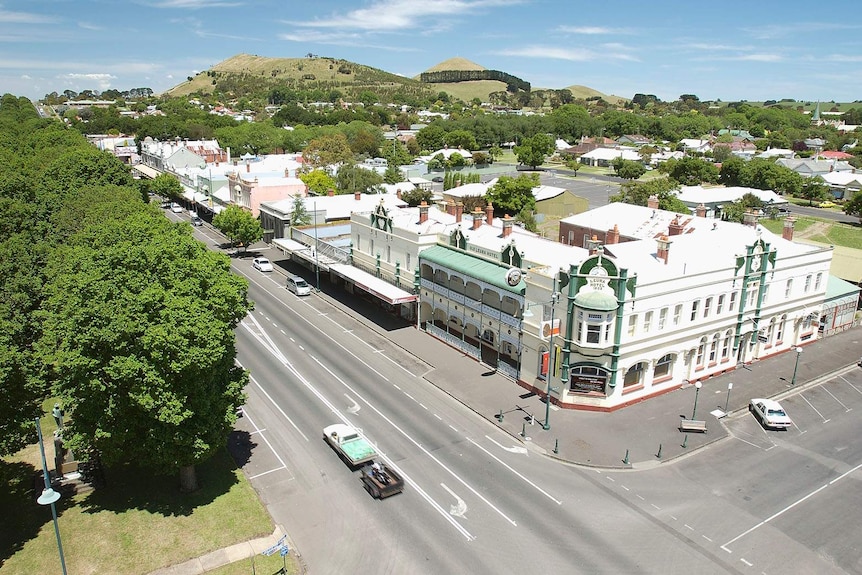 A view of a country town's buildings and trees from a high vantage point.