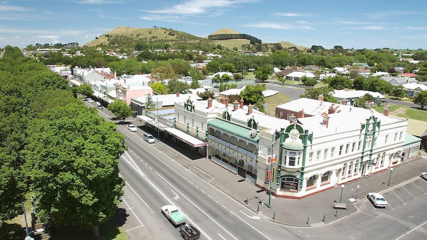 A view of a country town's buildings and trees from a high vantage point.