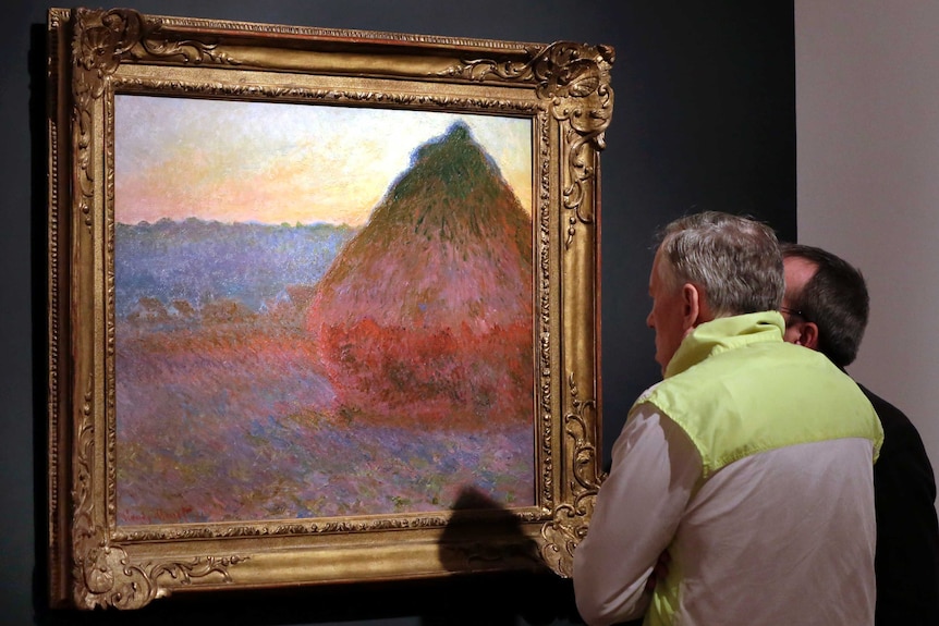 People look at Claude Monet's Grainstack painting.