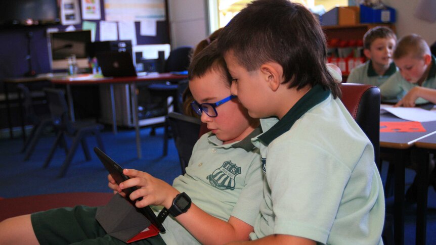 Mount Ousley Public School kindergarten pupils using an iPad in class.