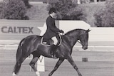 A black and white photo of a dressage horse ridden by a young woman circa 1980s.