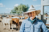Queensland cattle producer Melinee Leather in the cattle yard on her property with cattle in the background.