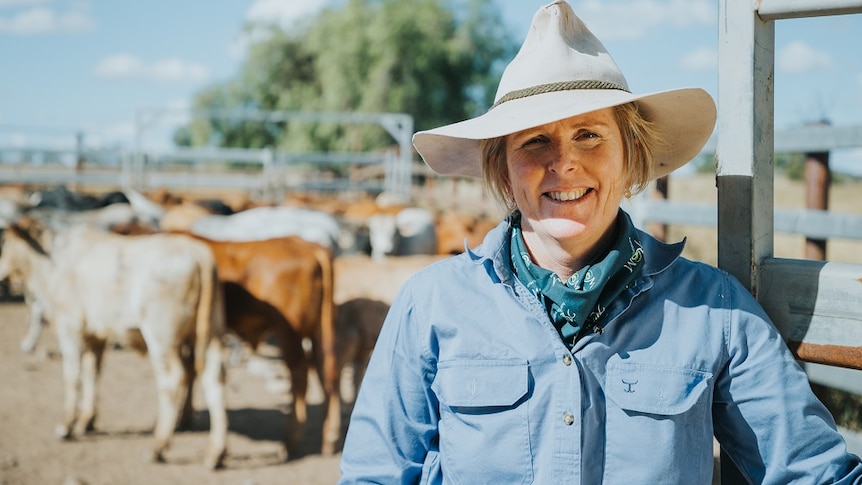 Queensland cattle producer Melinee Leather in the cattle yard on her property with cattle in the background.