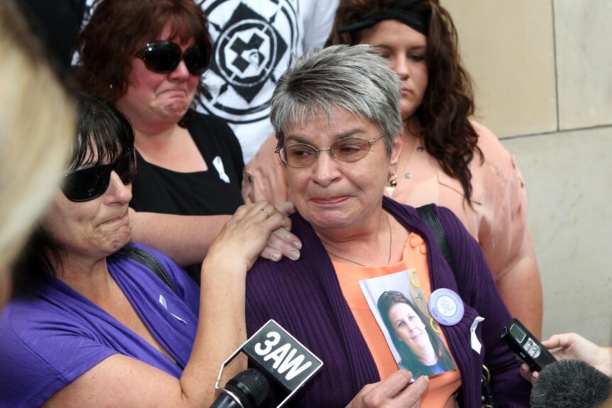 Helen Wicking holds a photo of her murdered daughter, Joanne Wicking, outside court.