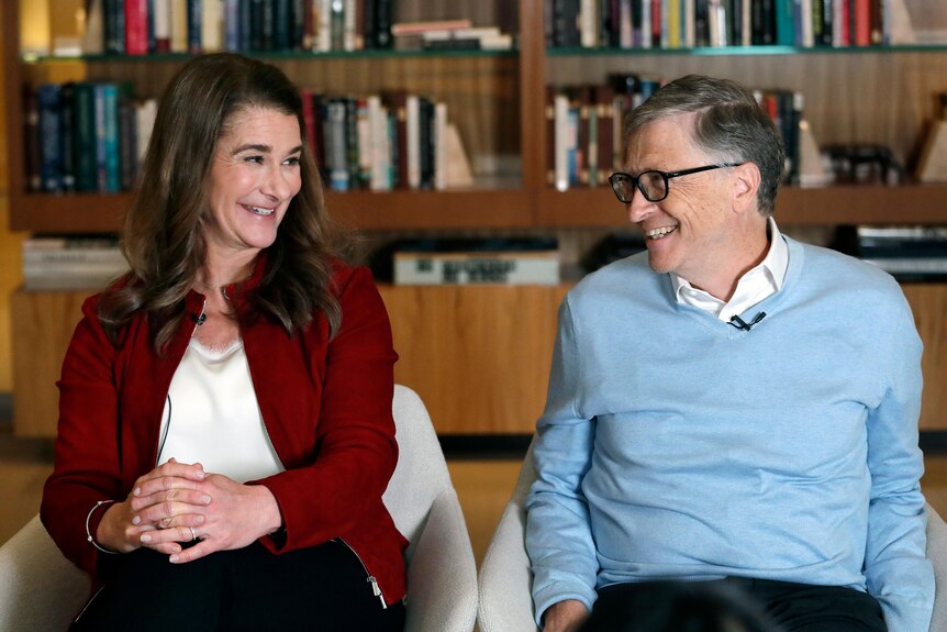 Melinda Gates smiles at Bill Gates, who is sitting next to her. 