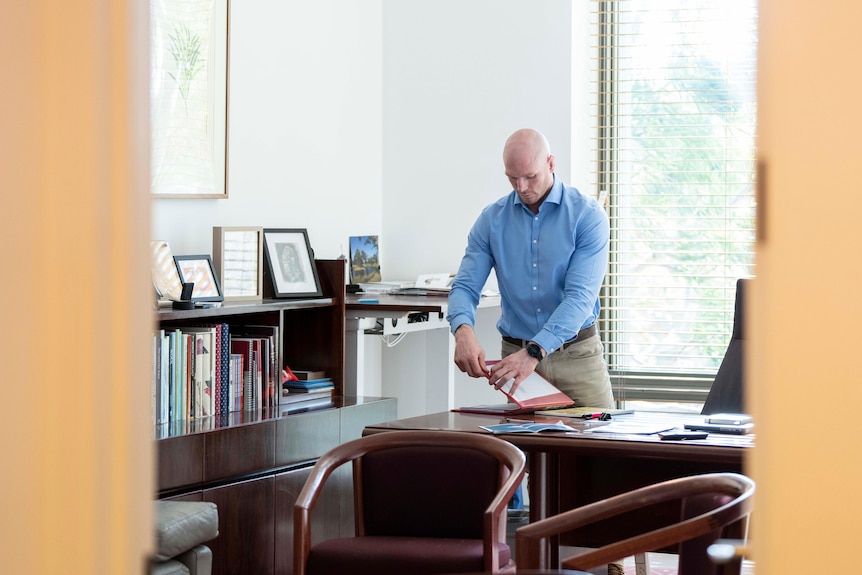 a bald young man in his office