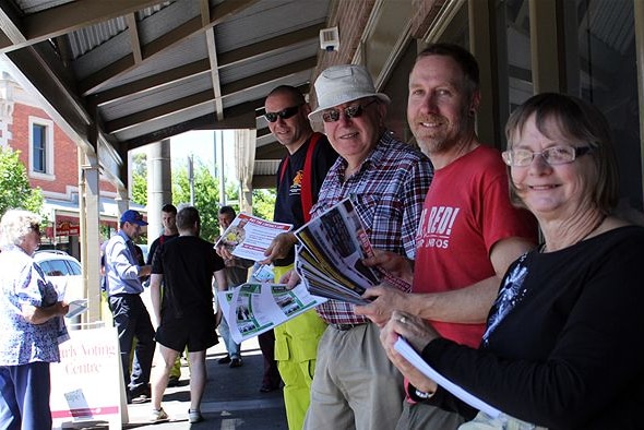 Volunteers hand out how to vote cards for the 2014 Victorian state election.