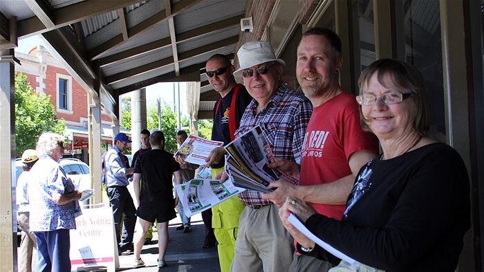 Volunteers hand out how to vote cards for the 2014 Victorian state election.