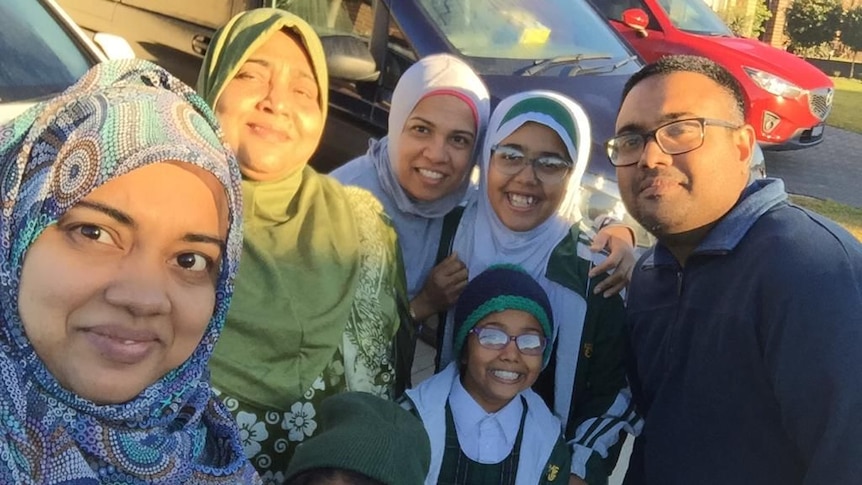 Rizan Rizvi and his family: mum, sister and three daughters pose for a selfie outside. 
