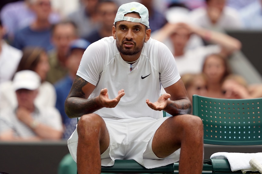 Nick Kyrgios se sienta y gesticula.