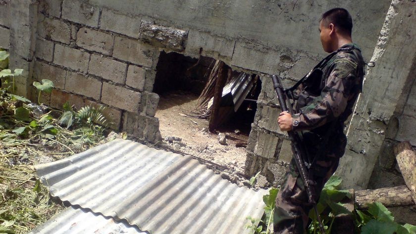 A police commando inspects the hole dug in a concrete wall of the Basilan Provincial Jail