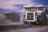 Two coal trucks pass each other on an open-cut mine in Collie, Western Australia.