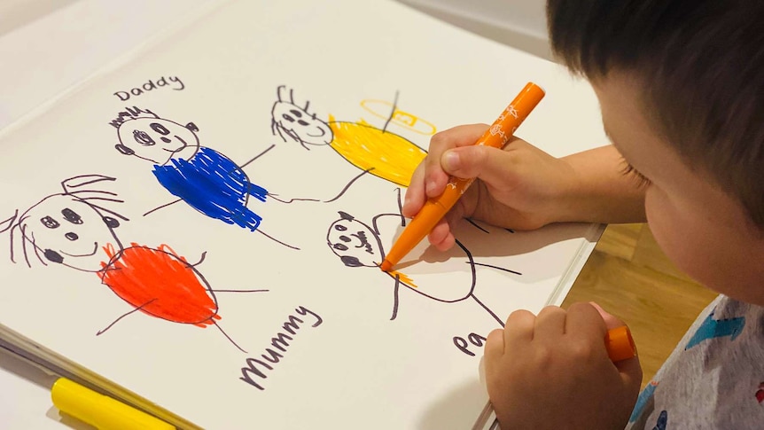 Child drawing a picture of a family