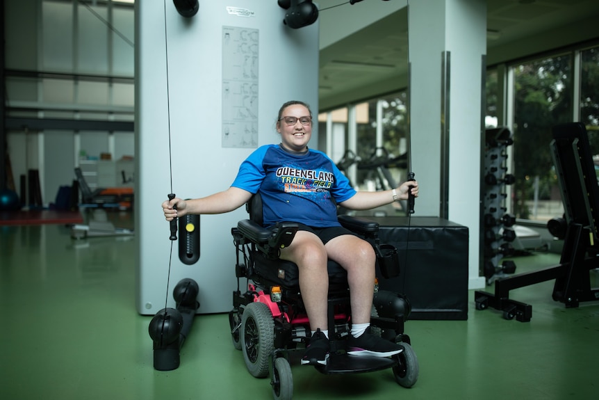 Wheelchair user Chloe Tookey uses upper body gym machine