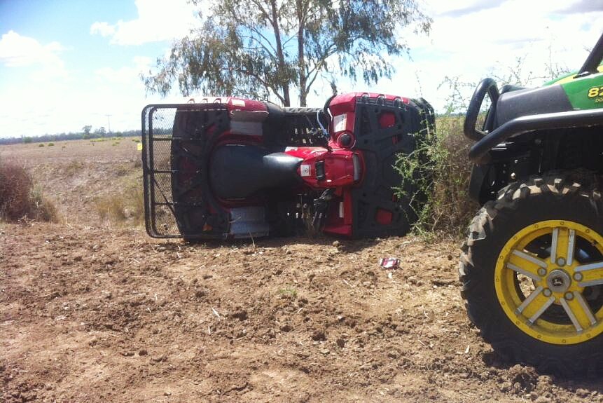 A quad bike lies on its side after a rollover