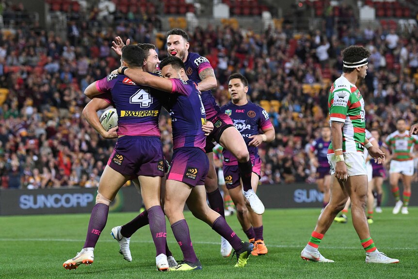 Corey Oates gets swamped upon as the Broncos celebrate a try he scored against the Rabbitohs.