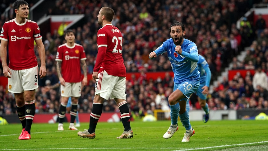 Bernado Silva runs off to celebrate as Manchester United defenders look sad behind him
