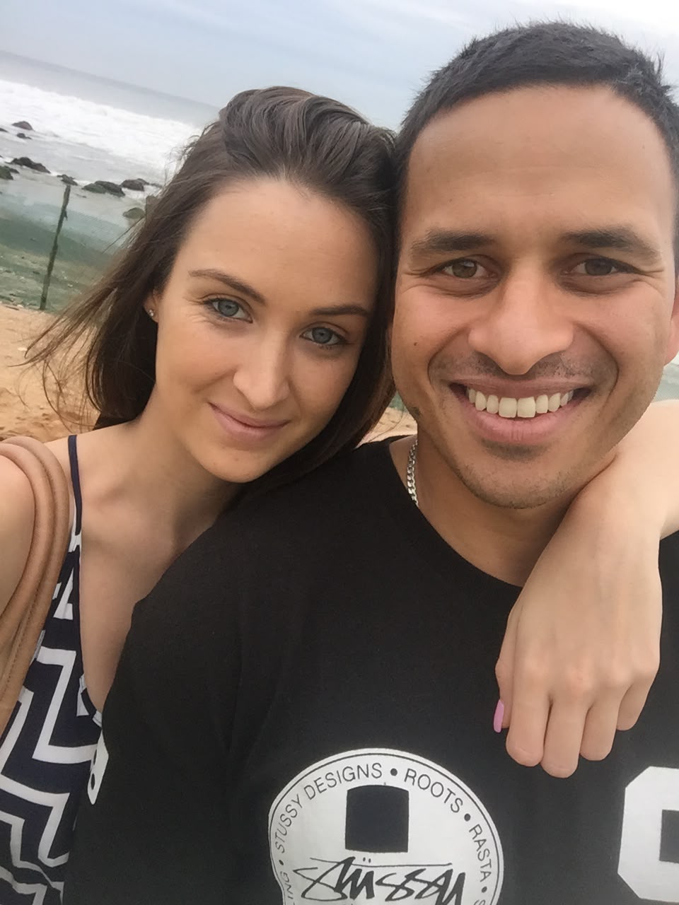 Rachel and Usman Khawaja smile as they take photo close together in selfie style.