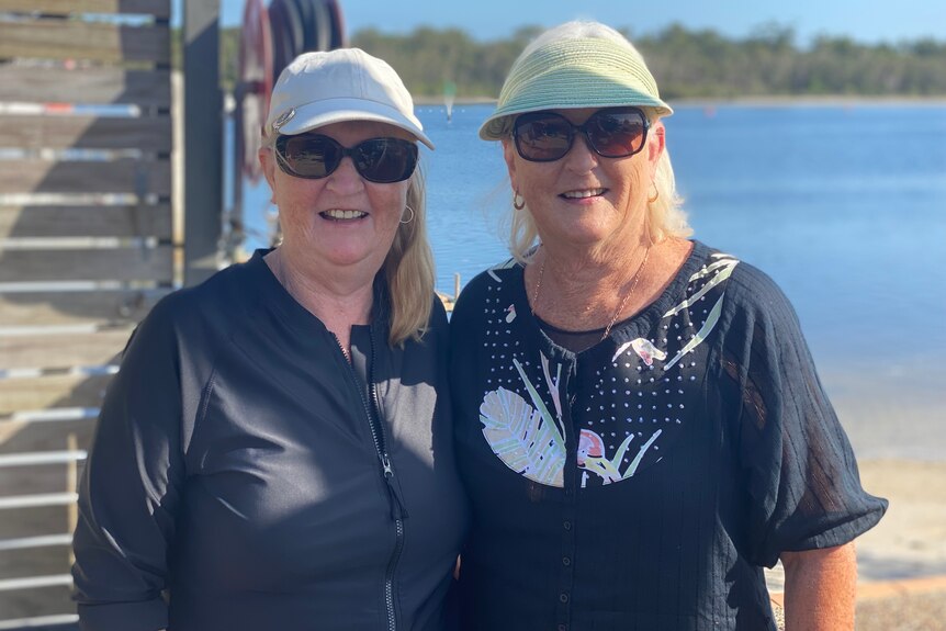 Two middle aged ladies smiling in front of Tin Can Bay dolphin centre