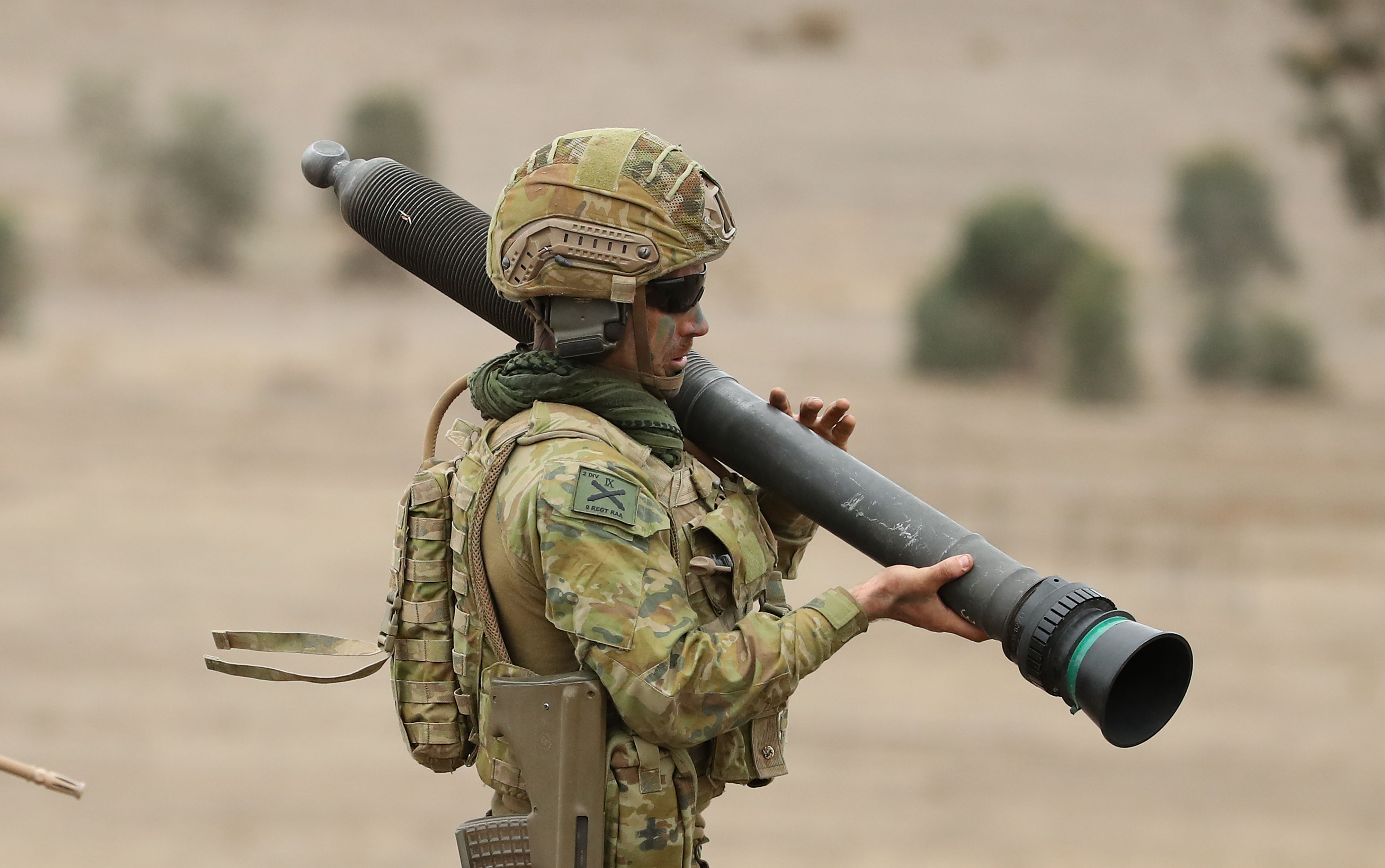An soldier holds a Carl Gustav rifle - a large weapon - over his shoulder.