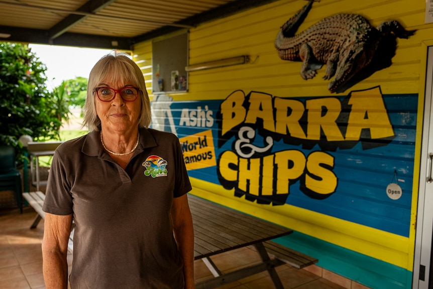 Woman standing in front of fish and chip shop 