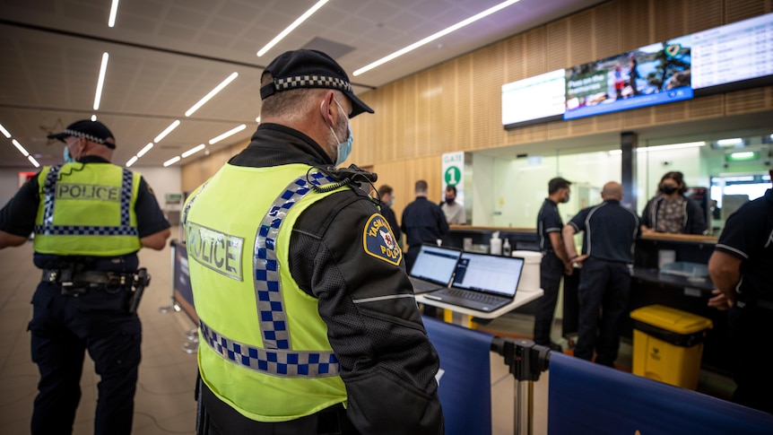 two police officers in high vis, shown side-on and back-on, at Hobart Airport 