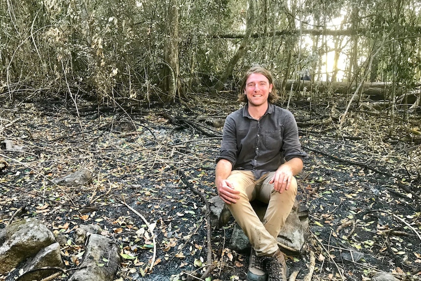 Patrick Norman sits surrounded by trees