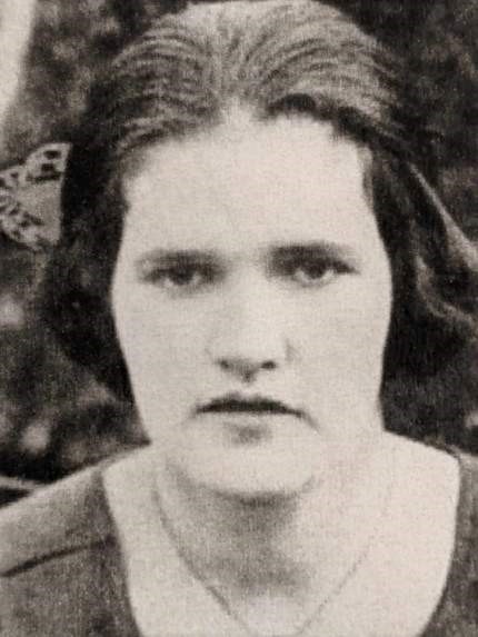 A black and white close up portrait of a woman's face with dark hair.