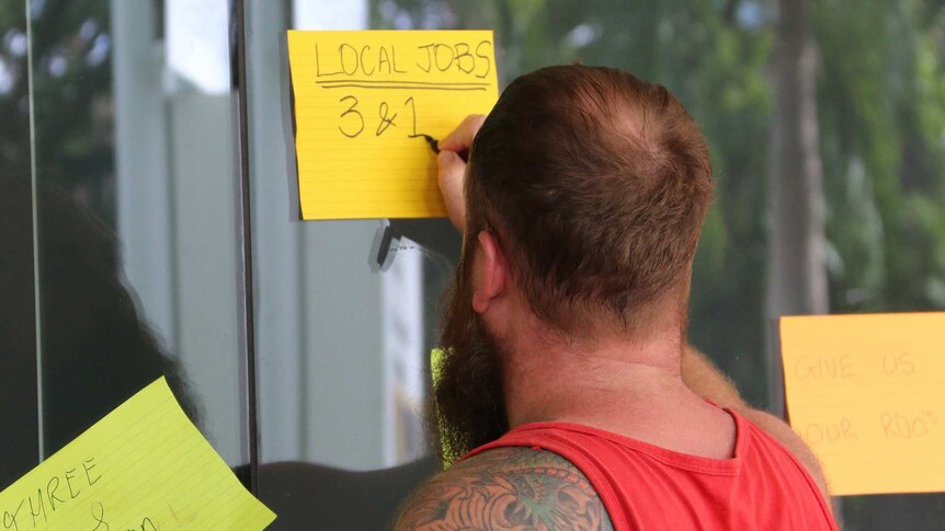 An INPEX worker writes his concerns on a note stuck on the window at the JKC office in Darwin.